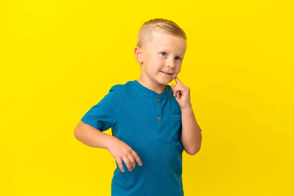 Μικρό Ρωσικό Αγόρι Απομονωμένο Κίτρινο Φόντο Σκέφτεται Μια Ιδέα Ενώ — Φωτογραφία Αρχείου