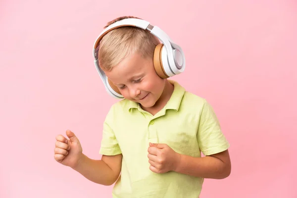 被粉色背景隔离的俄罗斯小男孩听着音乐 — 图库照片