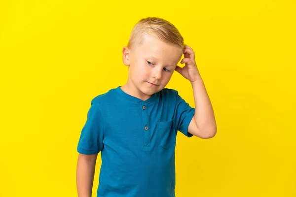 Mały Rosyjski Chłopiec Odizolowany Żółtym Tle Mając Wątpliwości — Zdjęcie stockowe