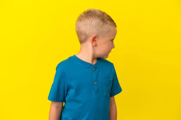 Mały Rosyjski Chłopiec Odizolowany Żółtym Tle Patrząc Bok — Zdjęcie stockowe