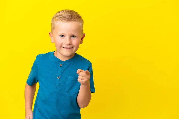 俄罗斯小男孩在黄色背景下被隔离 手指指向侧面 展示了一种产品 — 图库照片