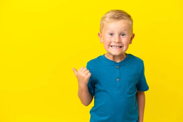 Little Russian Boy Isolated Yellow Background Pointing Side Present Product — 图库照片