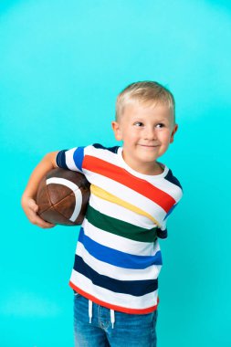 Küçük Rus çocuk soyutlanmış arka planda rugby oynuyor.