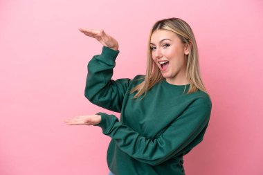 Pembe arka planda izole edilmiş beyaz bir kadın ilan vermek için kopyalama alanı tutuyor.