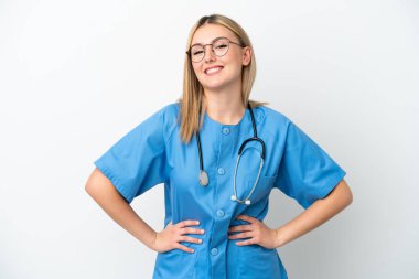 Beyaz arka planda izole genç cerrah kadın kolları kalçasında ve gülümsüyor