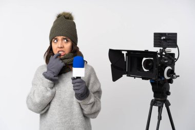 Elinde mikrofon olan gazeteci kadın izole edilmiş beyaz arka planda tedirgin ve korkmuş bir şekilde haberleri sunuyor.