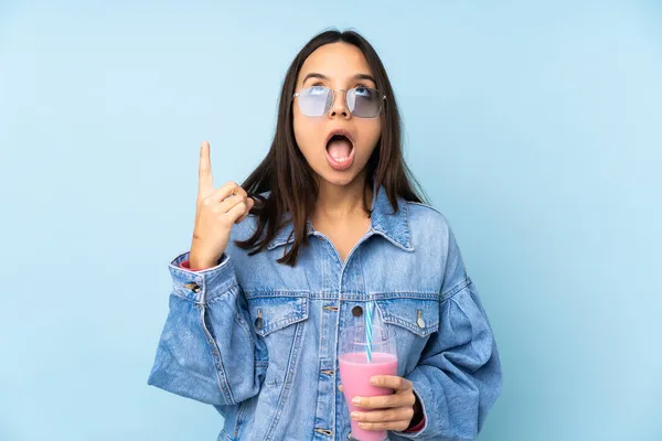 Jovem Com Batido Morango Sobre Fundo Azul Isolado Apontando Para — Fotografia de Stock