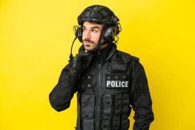 Özel Tim 'in beyaz adamı sarı arka planda izole edilmiş bir şekilde yukarı bakarken bir fikir düşünüyor.