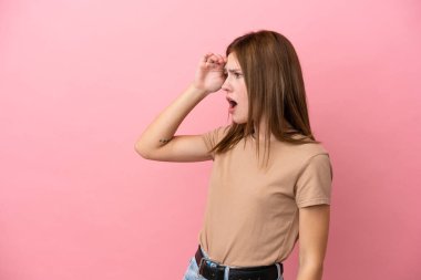 Pembe arka planda izole edilmiş genç bir İngiliz kadın.