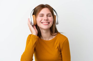Genç İngiliz kadın beyaz arka planda izole edilmiş müzik dinliyor.