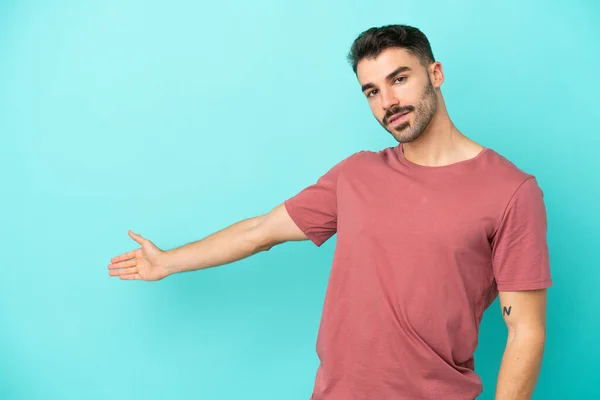 Joven Hombre Caucásico Aislado Sobre Fondo Azul Extendiendo Las Manos —  Fotos de Stock