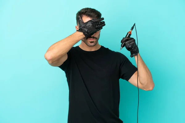 Young Tattoo Artist Man Isolated Blue Background Covering Eyes Hands — Stockfoto
