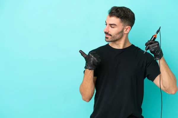 Jonge Tattoo Artiest Man Geïsoleerd Blauwe Achtergrond Wijzend Naar Zijkant — Stockfoto