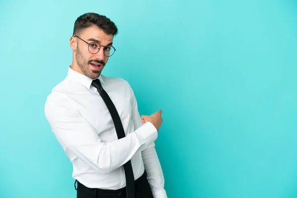 Negocio Hombre Caucásico Aislado Sobre Fondo Azul Apuntando Hacia Atrás —  Fotos de Stock