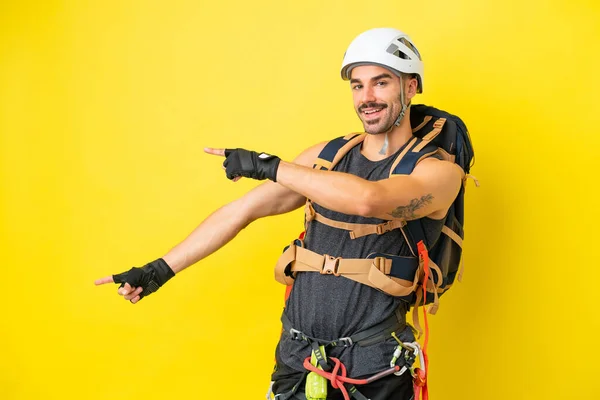 Jonge Kaukasische Bergbeklimmer Man Geïsoleerd Gele Achtergrond Wijzende Vinger Naar — Stockfoto