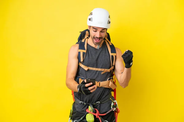 Jonge Kaukasische Bergbeklimmer Man Geïsoleerd Gele Achtergrond Verrast Stuurt Een — Stockfoto