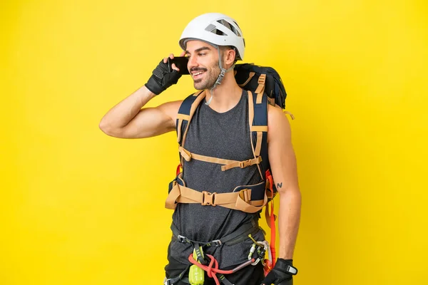 Jonge Kaukasische Bergbeklimmer Man Geïsoleerd Gele Achtergrond Houden Van Een — Stockfoto