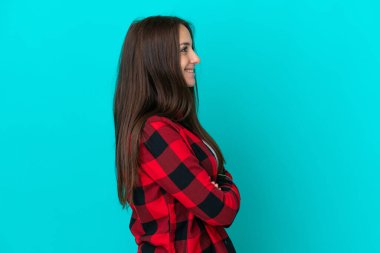 Genç Ukraynalı kadın mavi arka planda yan pozisyonda izole edildi