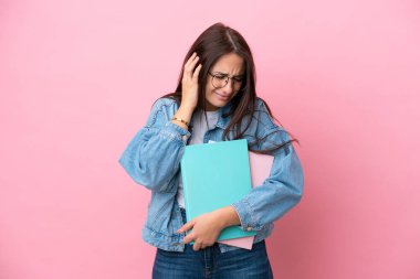 Pembe arka planda izole edilmiş genç Ukraynalı kadın hayal kırıklığına uğramış ve kulaklarını kapatmış.