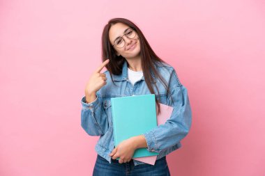 Pembe arka planda izole edilmiş genç Ukraynalı bir kadın jest yapıyor.