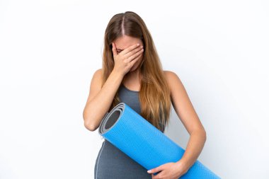 Genç sporcu kadın yoga derslerine giderken elinde yorgun ve hasta bir ifadeyle paspas tutuyor.