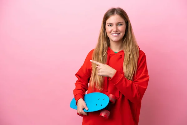 Junge Blonde Frau Isoliert Auf Rosa Hintergrund Mit Einem Skate — Stockfoto