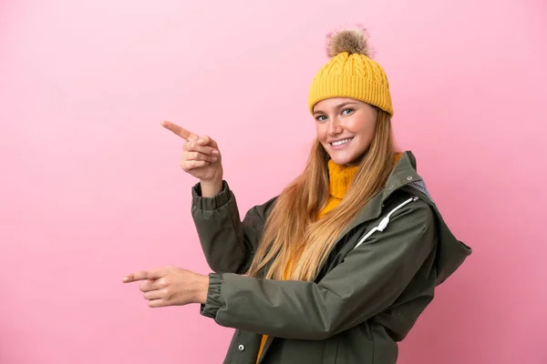 Junge Blonde Frau Winterjacke Isoliert Auf Rosa Hintergrund Zeigt Mit — Stockfoto