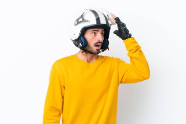 Beyaz arka planda izole edilmiş motosiklet kasklı genç beyaz adam yan tarafa bakarken sürpriz jest yapıyor.