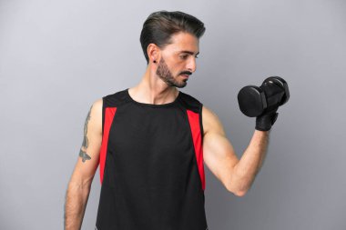 Gri arka planda izole edilmiş beyaz bir adam halter yapıyor.