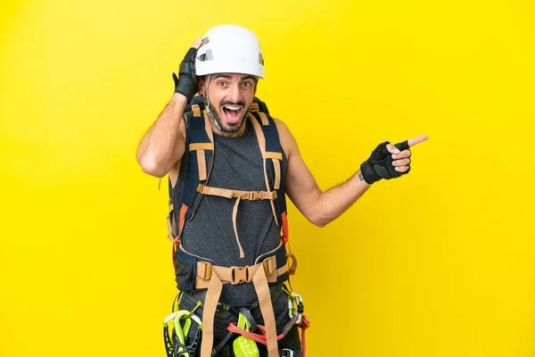 Junge Kaukasische Bergsteiger Mann Isoliert Auf Gelbem Hintergrund Überrascht Und — Stockfoto