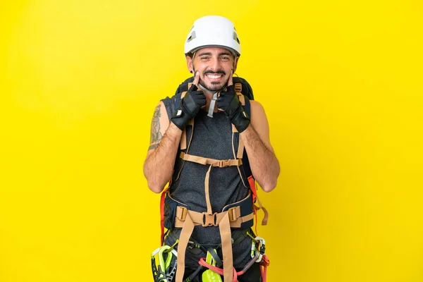Młody Kaukaski Alpinista Człowiek Odizolowany Żółtym Tle Uśmiecha Się Szczęśliwy — Zdjęcie stockowe