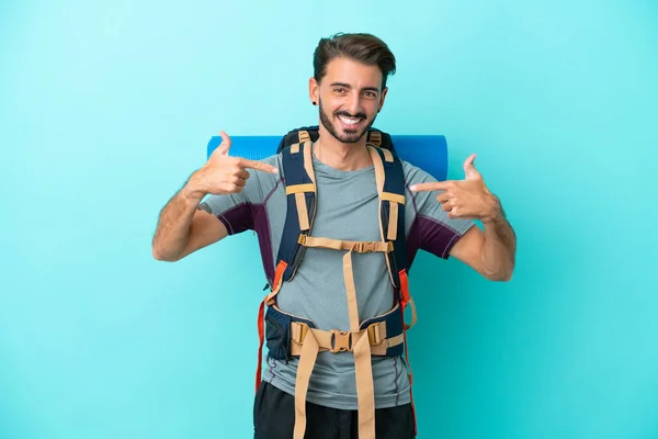 Ung Bergsklättrare Man Med Stor Ryggsäck Isolerad Blå Bakgrund Stolt — Stockfoto