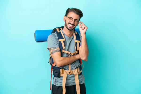 Junge Bergsteiger Mann Mit Einem Großen Rucksack Isoliert Auf Blauem — Stockfoto