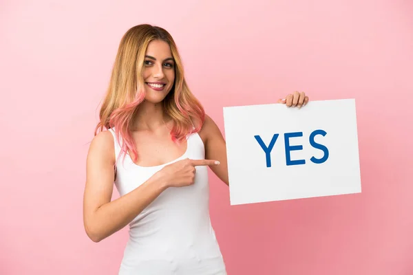 Молода Жінка Над Ізольованим Рожевим Тлом Тримає Плакат Текстом Yes — стокове фото