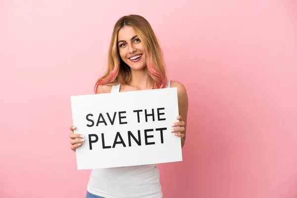 一位年轻女子 带着写着 拯救地球 字样的标语牌 带着快乐的表情 站在孤独的粉色背景上 — 图库照片