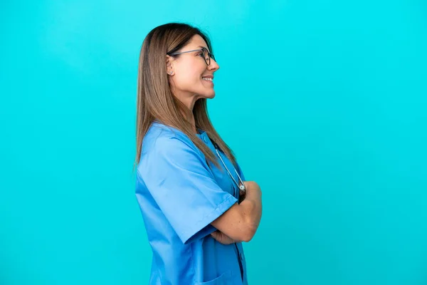 Chirurg Średnim Wieku Kobieta Izolowana Niebieskim Tle Pozycji Bocznej — Zdjęcie stockowe
