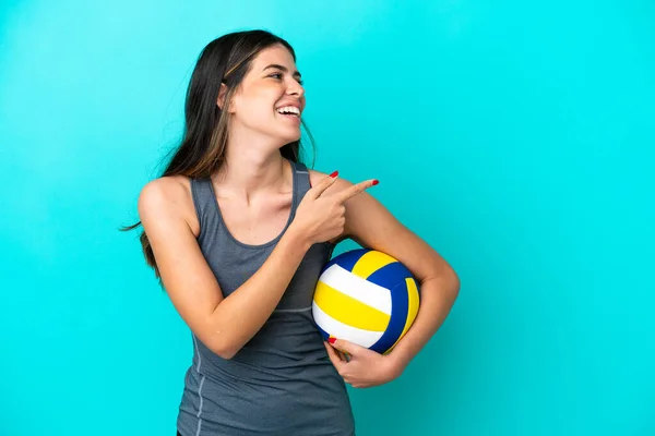青の背景に指を向け 製品を提示バレーボールをプレイ若いイタリアの女性 — ストック写真