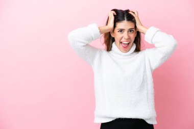 Pembe arka planda izole edilmiş genç bir İtalyan kadın gergin hareketler yapıyor.