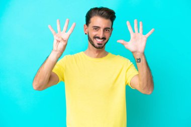 Mavi arka planda izole edilmiş beyaz bir adam dokuz parmaklı sayıyor.