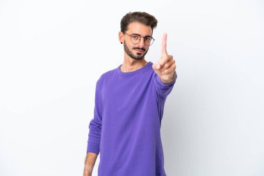 Beyaz arka planda izole edilmiş genç beyaz adam parmağını kaldırıyor ve gösteriyor.