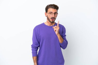 Beyaz arka planda izole edilmiş genç beyaz bir adam çözümü bulmak için parmağını kaldırıyor.