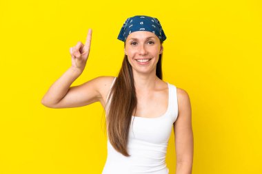 Sarı arka planda izole edilmiş genç İngiliz kadın harika bir fikre işaret ediyor.