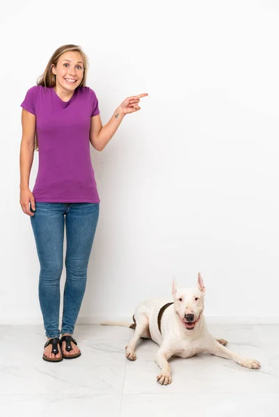 Junge Engländerin Mit Hund Auf Weißem Hintergrund Überrascht Und Zeigt — Stockfoto