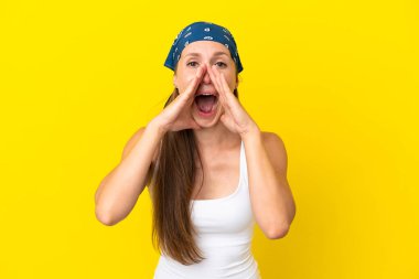 Sarı arka planda izole edilmiş genç bir İngiliz kadın bağırıyor ve bir şeyler söylüyor.