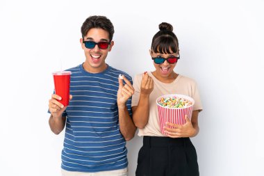 Beyaz arka planda 3 boyutlu gözlüklü ve elinde patlamış mısırla genç melez arkadaşlar.