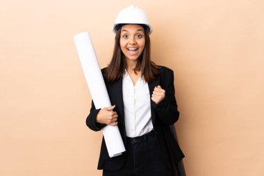 Genç mimar kadın, izole edilmiş arkaplandaki planları elinde tutuyor ve galibiyeti kutluyor.