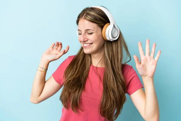 Jonge Kaukasische Vrouw Geïsoleerd Blauwe Achtergrond Luisteren Muziek Dansen — Stockfoto