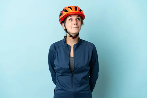 Молодая Женщина Велосипедист Изолированы Синем Фоне Глядя Вверх — стоковое фото