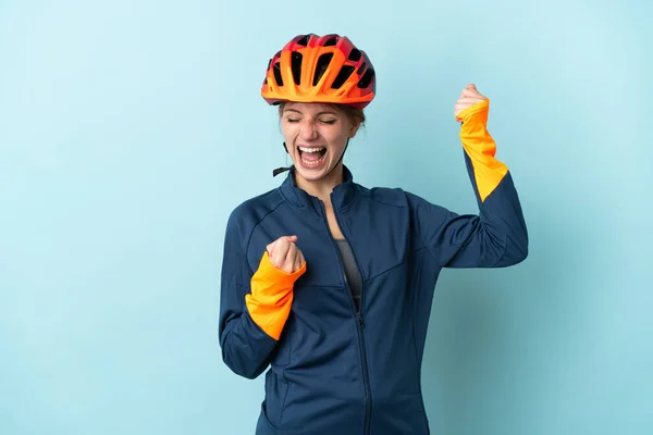 Молодая Женщина Велосипедистка Синем Фоне Празднует Победу — стоковое фото