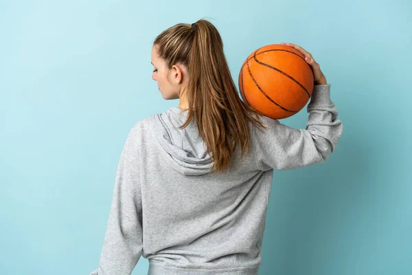 Jonge Kaukasische Vrouw Geïsoleerd Blauwe Achtergrond Spelen Basketbal Achterste Positie — Stockfoto